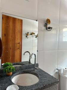 een badkamer met een wastafel en een spiegel bij Nosso Chalet in Lavras Novas