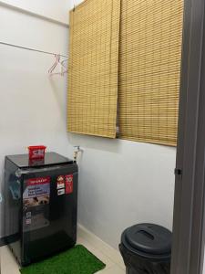 a bathroom with a toilet and a green rug at Ipoh Homestay - Manhattan Condominium with Water Park & Leisure Facilities in Ipoh