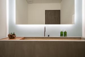 a bathroom with a sink with two green bottles at 1 Homes Preview Cabo in Cabo San Lucas