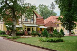 duży dom z ogrodem przed nim w obiekcie Waldhotel Forsthaus Hainholz w mieście Pritzwalk