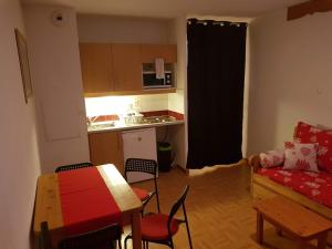 uma pequena sala de estar com uma mesa e uma cozinha em Le studio 1800 aux pieds des pistes em Puy-Saint-Vincent
