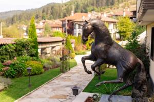 a bronze statue of a horse in a garden at Armaco Residence in Koprivshtitsa