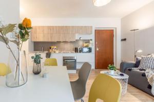 cocina y sala de estar con mesa y sillas en Ginger-Appartamento a due passi dal centro con posto auto - Porta Romana en Siena