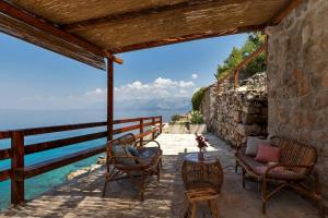 a patio with chairs and a table with a view of the water at Holiday Home -Didina in Sućuraj