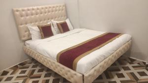 een groot bed in een slaapkamer met een witte muur bij HOTEL EAGLE TOP 1 in Mysore