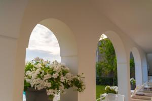 プライアーノにあるVilla Giuliaの花瓶の白い花のアーチ道