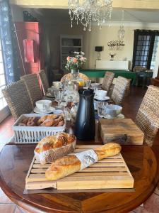 a table with bread and croissants on top of it at La Belle Chaumière in Bretagne-de-Marsan