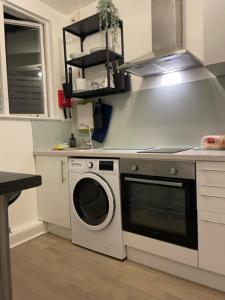 a kitchen with a washing machine and a stove at The South Kensington Apartments in London