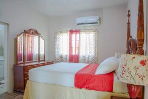 una camera con letto, cassettiera e finestre di Savan Suite - Caribbean Estates - Gated Community a Portmore