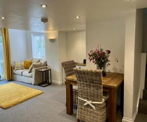 un soggiorno con tavolo, sedie e divano di The Coach House - with hot tub a St Austell