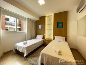 Cette chambre comprend 2 lits et une fenêtre. dans l'établissement Apartamento 2 suítes - 650m da Rua Coberta, à Gramado