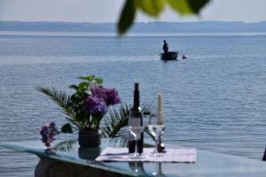 een man in een boot op het water met een tafel met een fles wijn bij Inselglück auf der Fraueninsel 