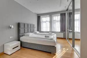 um quarto com uma cama grande e janelas em Dom & House Apartments - Old Town Tobiasz Residence - Fitness & Parking em Gdansk