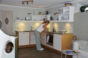 a woman standing in a kitchen preparing food at Inselglück auf der Fraueninsel in Chiemsee