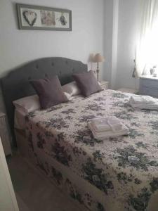 1 dormitorio con 1 cama grande con manta de flores en Appart T3 à louer en Andalousie, en Chiclana de la Frontera