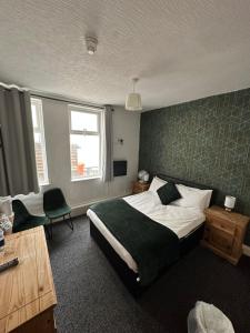 a bedroom with a bed with a green accent wall at North Ocean Hotel in Blackpool