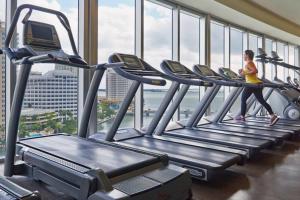 a woman running on a treadmill in a gym at Studio at Icon Brickell Luxury Waterfront Building in Miami