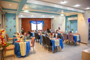 HOTEL MICKEL في دوالا: غرفة طعام مع طاولات وكراسي زرقاء