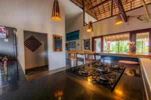 a kitchen with a stove top oven in a room at Villa Pousada 35knots Brasil in Ponta do Anel