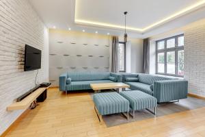 a living room with couches and a table and a tv at Dom & House Apartments - Old Town Tobiasz Residence - Fitness & Parking in Gdańsk