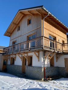 a wooden house with a balcony on the side of it at Chalet cosy et confortable in Savoie
