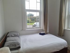 a bed in a room with a window at Grand Norfolk in Mundesley