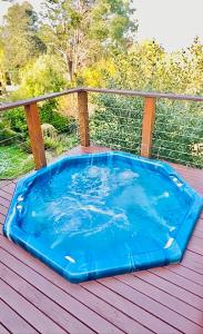 bañera de hidromasaje azul en una terraza de madera en Mountain Villa in Dandenong Ranges en Mount Dandenong