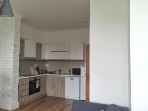 a kitchen with white appliances and a brick wall at Grand Norfolk in Mundesley