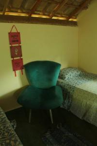 um quarto com uma cadeira verde e uma cama em Casa Néctar em Lençóis