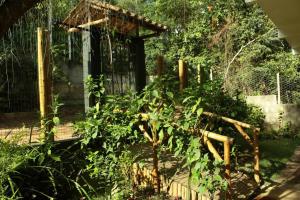 um jardim com uma cerca de madeira e um edifício em Casa Néctar em Lençóis