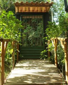 uma entrada para uma porta verde com um passadiço de madeira em Casa Néctar em Lençóis
