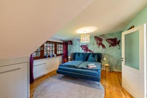 a bedroom with a blue chair in a room with a wall with fish on it at Sittermansweg in Geldern