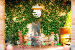 a ivy covered wall with a table and a clock at Castello di Montalbano in San Jacopo al Girone