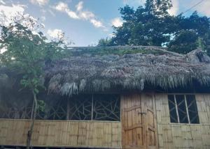 un edificio con techo de césped y puerta en Cabanas Armonia, en Cotundo