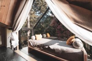 uma cama num quarto com uma grande janela em Villa Sofía Apart Hotel em San Carlos de Bariloche