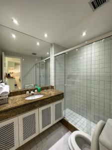 Apartamento no Porto Real Resort com vista espetacular p/ 6 adultos e 4 adolescentes في مانغاراتيبا: حمام مع دش ومغسلة وحوض استحمام