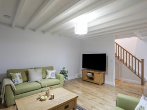 a living room with a couch and a tv at Glanrafon in Caernarfon