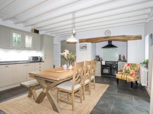a kitchen and dining room with a wooden table and chairs at Glanrafon in Caernarfon