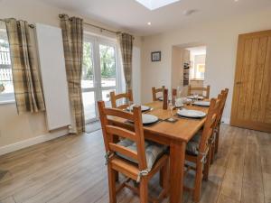 a dining room with a wooden table and chairs at Buckled Barn in Dumfries