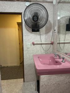 ein Bad mit einem rosa Waschbecken und einem Ventilator in der Unterkunft Dpto 1 Corrientes in Corrientes