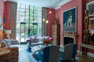a living room with pink walls and a fireplace at Crosby Street Hotel in New York