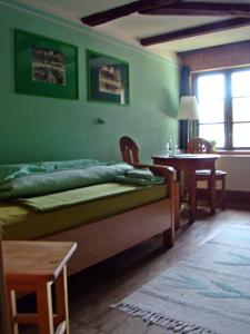 een groene slaapkamer met een bed en een tafel bij Alte Ausspanne in Walkendorf