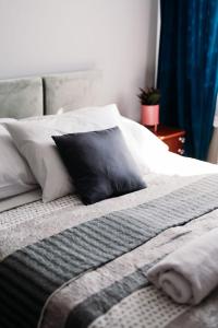 a bed with a black pillow and white pillows at Malibu in Brzeźnica +11 photos