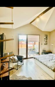ein Schlafzimmer mit einem Bett und einem Balkon in der Unterkunft Арт Мезонет Salem in Welingrad