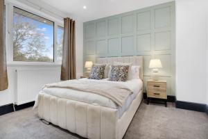 - une chambre avec un grand lit blanc et une fenêtre dans l'établissement Appealing 4-Bedroom Haven in Durham, Sleeps 7, à Durham