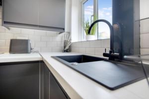 a kitchen with a black sink and a window at Appealing 4-Bedroom Haven in Durham, Sleeps 7 in Durham
