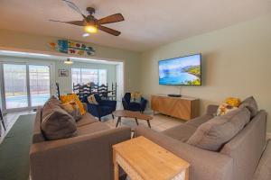 uma sala de estar com 2 sofás e uma televisão de ecrã plano em SEA STAR em Indian Harbour Beach