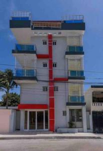 un edificio con una franja roja en el costado en Hotel La Playa en Santa Cruz de Barahona