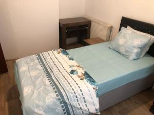 a bed with a blue and white comforter and a pillow at Beyoğlu/Taksim are also in a perfect location in Istanbul