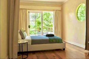 a bedroom with a bed and a large window at Mountain Villa in Dandenong Ranges in Mount Dandenong